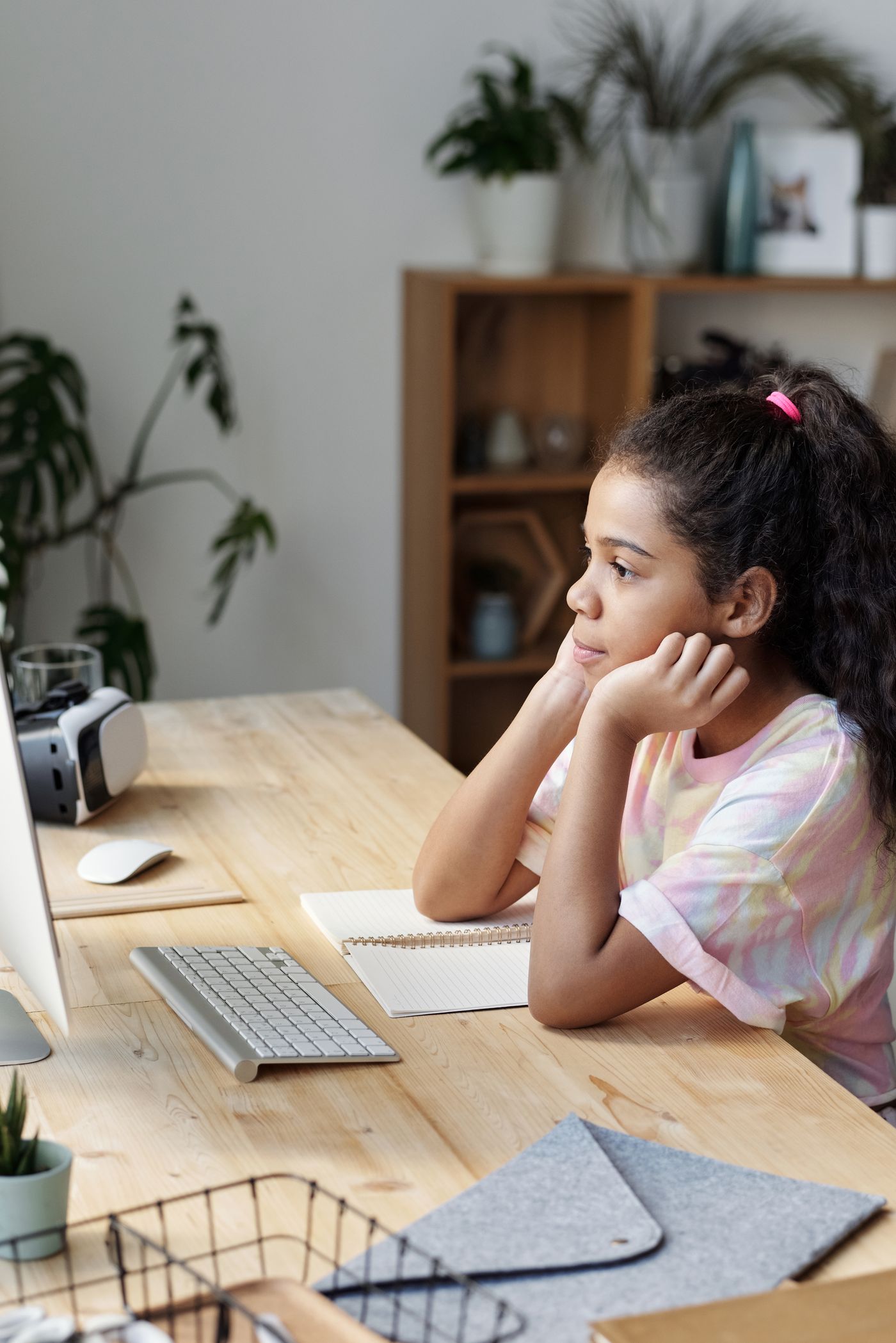 A child paused over schoolwork at a table